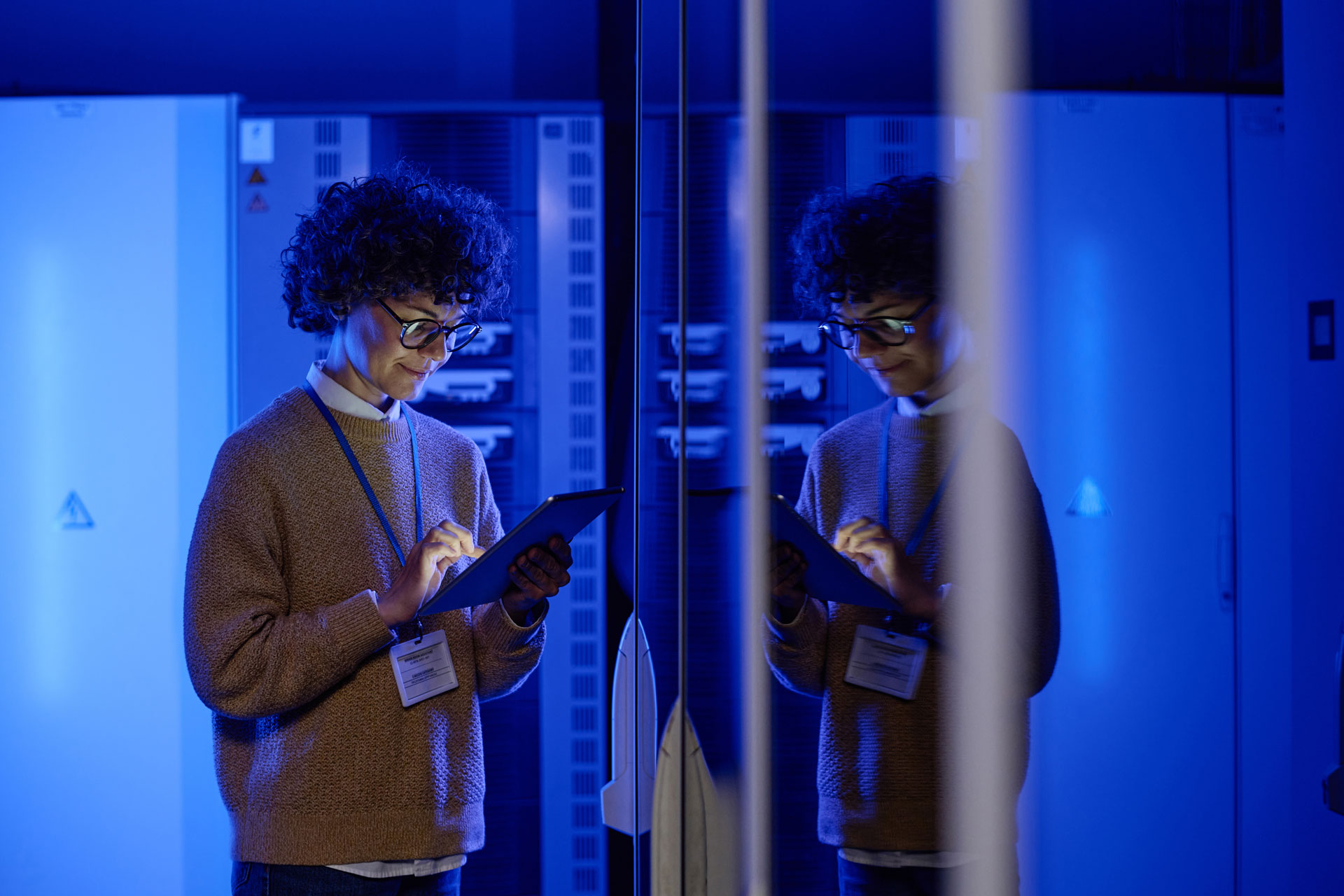 Une femme en train de classer des documents dans la salle des serveurs de stockage