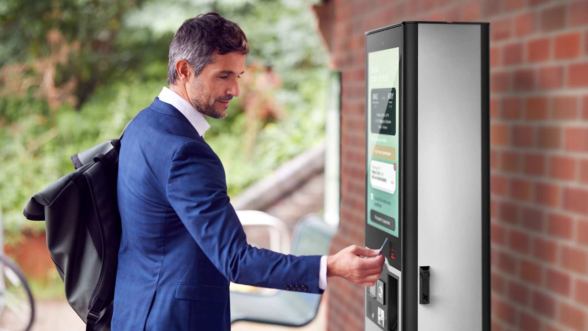 Un homme utilise Outdoor pour la billetterie dans une gare
